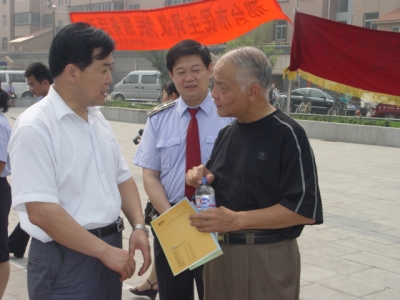 麻局长（左）、孟所长（中）给群众介绍计量工作情况